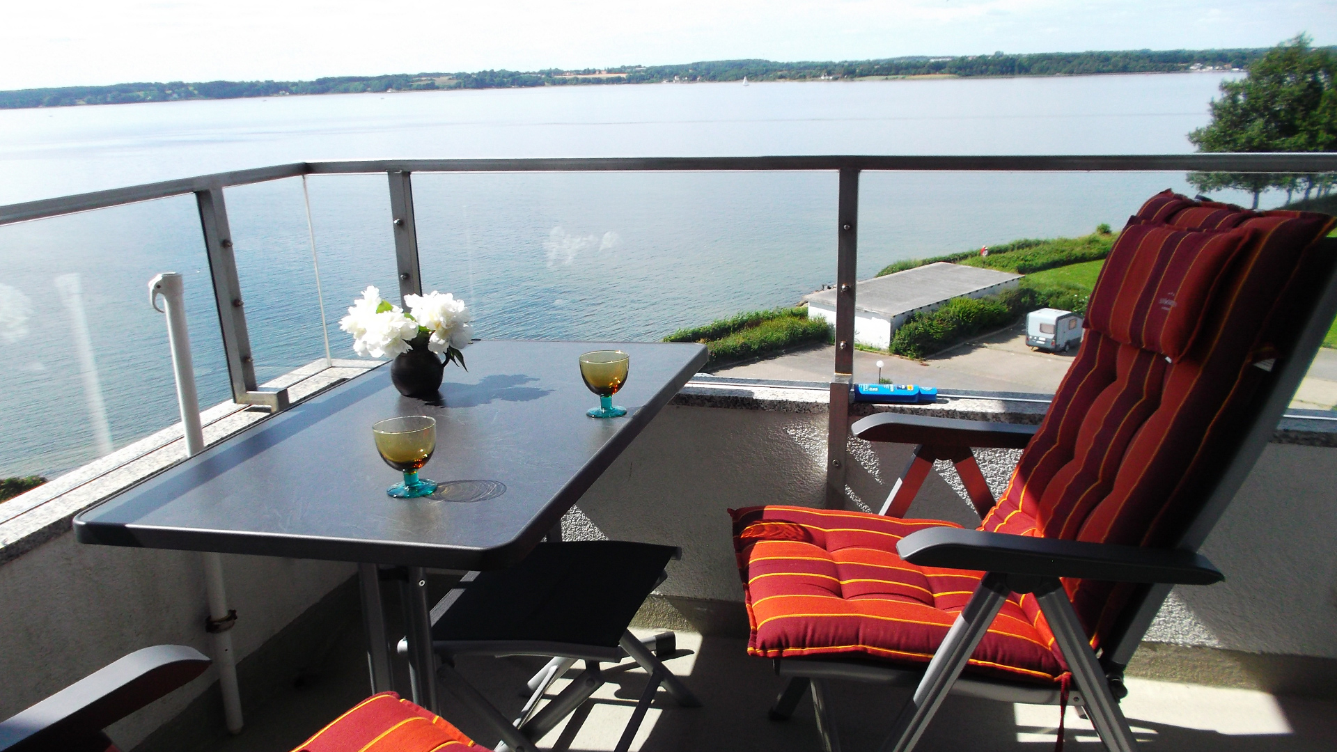 Genießen Sie die Aussicht auf das Meer aus der Loggia der Ferienwohnung Fiedler mit einem Glas Wein.